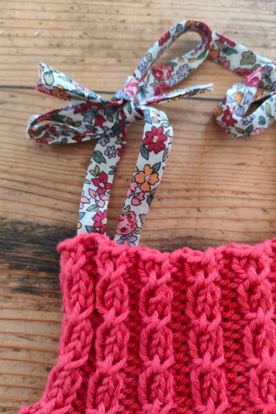 Barboteuse à torsades en pur coton, bretelles « Liberty » – Coloris « cerise » – Taille naissance-3 mois